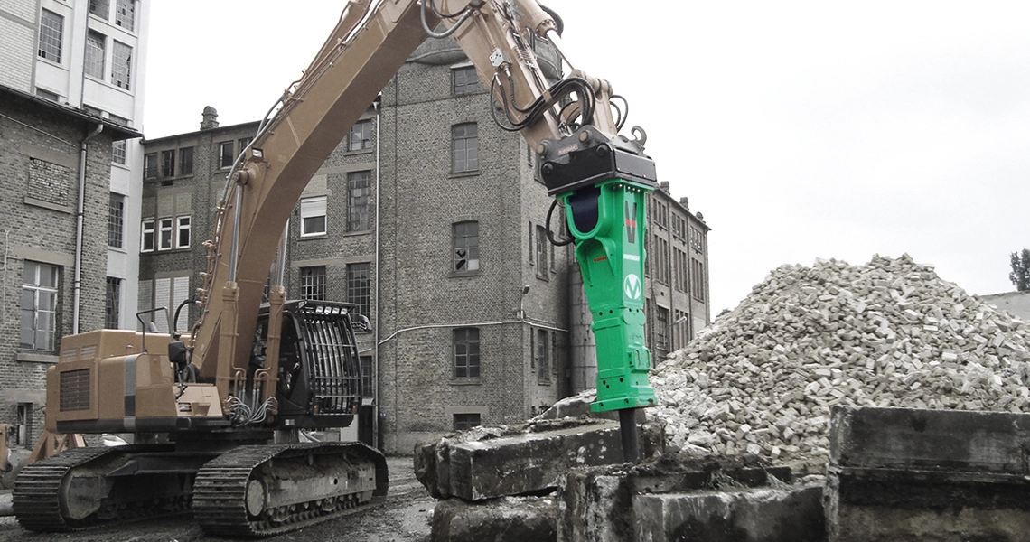 grön montabert hydraulhammare monterad på grävmaskin